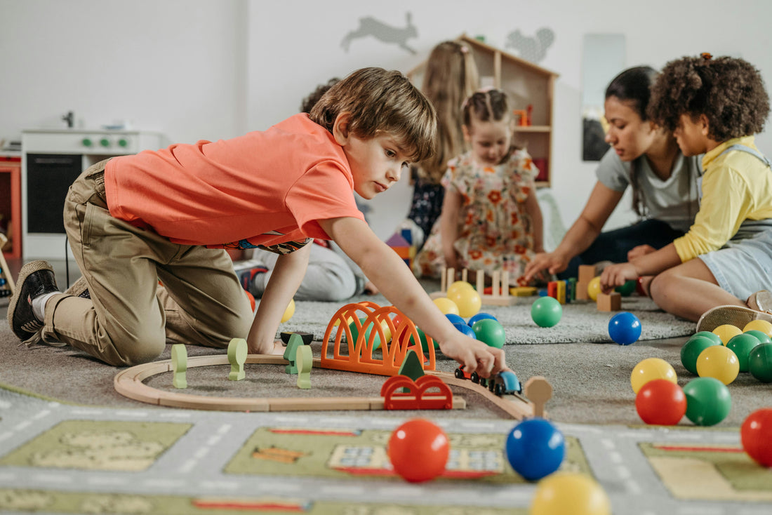 boy-in-orange-shirt-playing-train-toy-on-the-floor